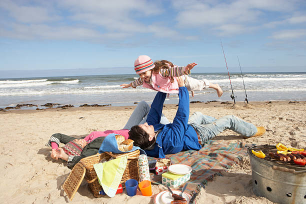 istock Family having Barbeque picnic on sandy beach 115768549