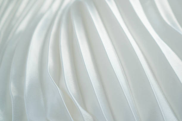 istock White silk or satin fabric folded background. Luxurious fabric cloth fold glamour background. Tender and elegant white silk background use for cosmetic store or spa salon. Wedding or Christmas background or New Year background design 1157688721