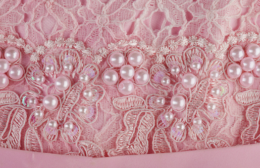 Pink pearls on dress macro close up view