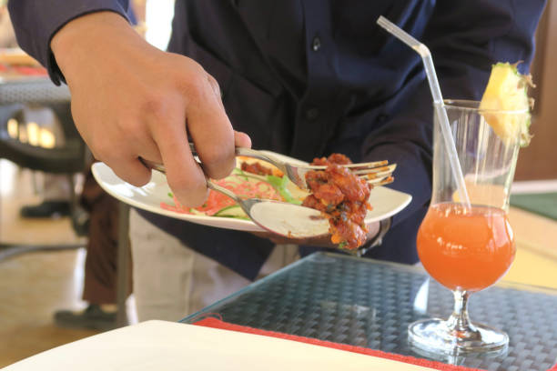 image of eating at indian restaurant meal with food being served by waiter using fork and spoon, spicy deep-fried chicken pakoras recipe, dining out with non-veg meat dish on table, served with indian salad, pineapple orange cocktail drink, delhi, india - non veg imagens e fotografias de stock