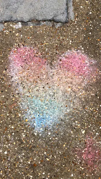 Photo of Image of pastel chalk rainbow heart on pavement for LGBT gay pride concept art for lesbian, gay, bisexual and transgender romance, LGBT rainbow flag for same sex couples and homosexual relationships, queer equality, gay rights, homophobia, diversity