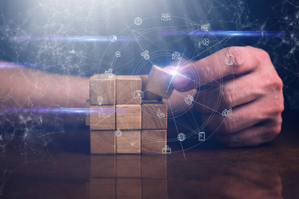 hombre de negocios tratar de construir bloque de madera en la mesa de madera y negro fondo de la organización empresarial concepto de inicio - stability fotografías e imágenes de stock