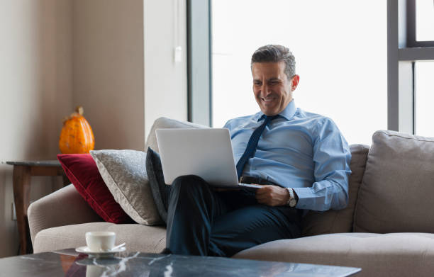 istock Happy businessman using laptop at home 1157697571