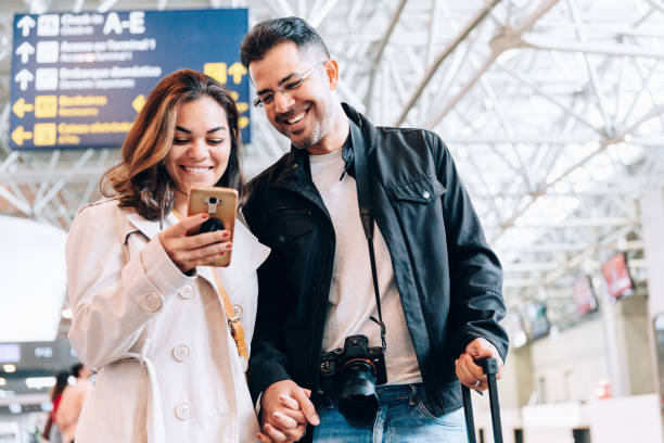 istock Couple using smartphone at the airport 1157700666