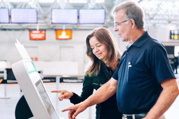 padre e hija usando el totem de check-in en el aeropuerto - tótem fotografías e imágenes de stock