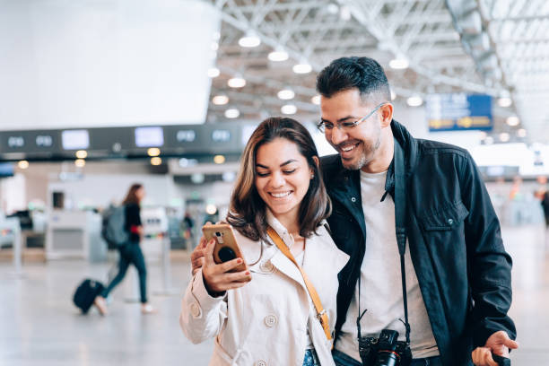 istock Couple using smartphone at the airport 1157700787