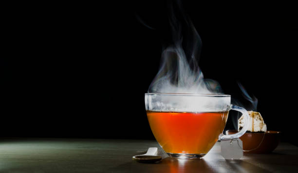istock glass cup with tea infusion, on black background with label to write text 1157702298