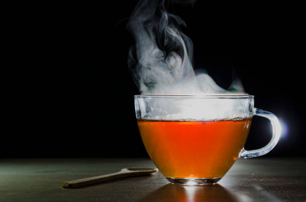 istock glass cup with tea infusion, on black background with label to write text 1157702302