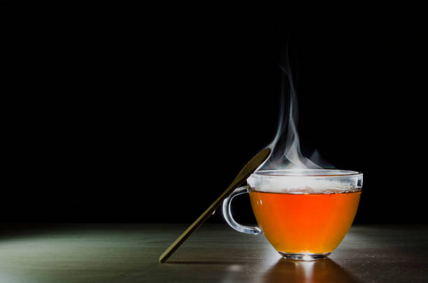istock glass cup with tea infusion, on black background with label to write text 1157702321