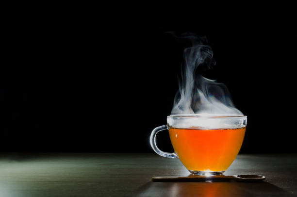istock glass cup with tea infusion, on black background with label to write text 1157702326