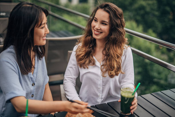 istock Two cheerful women having fun in a cafe 1157704976
