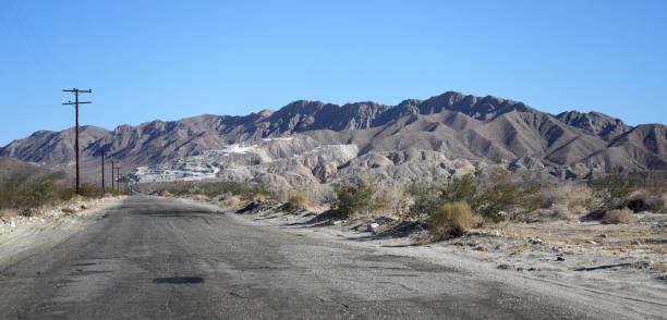 autostrada solitaria del deserto - arid climate asphalt barren blue foto e immagini stock