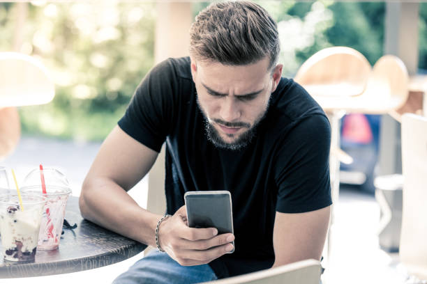 istock Young man holding cell phone 1157708859