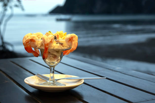 Cocktail salad with shrimp and seafood on a wooden table against the background of the sea. Cocktail salad with shrimp and seafood on a wooden table against the background of the sea. shrimp cocktail stock pictures, royalty-free photos & images