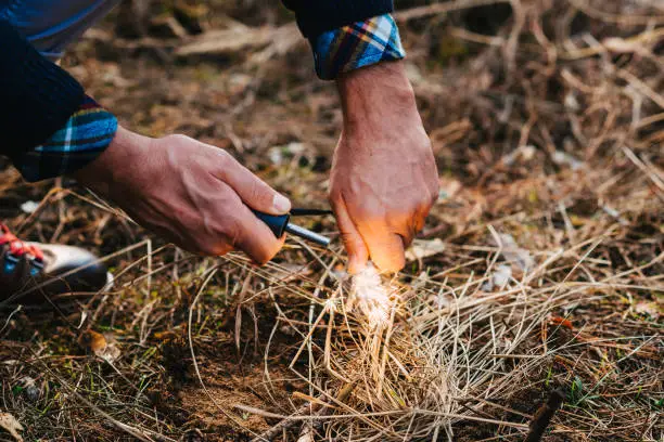 A man makes a fire with a flint