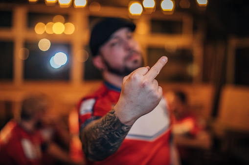 Man, football fan showing middle finger