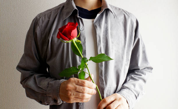 istock Men handing flowers a present. 1157715161