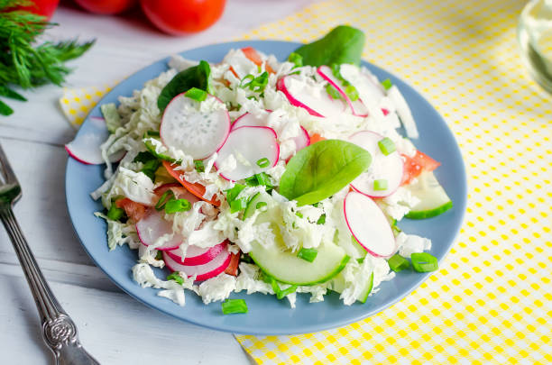Salad of young cabbage with corn and crab sticks in blue bowl