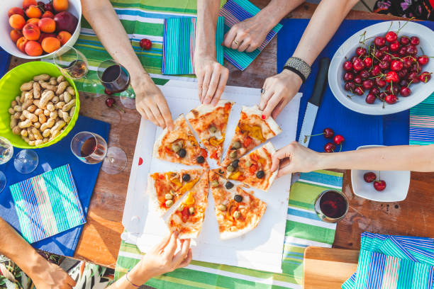 hands of girlfriends share slices of pizza