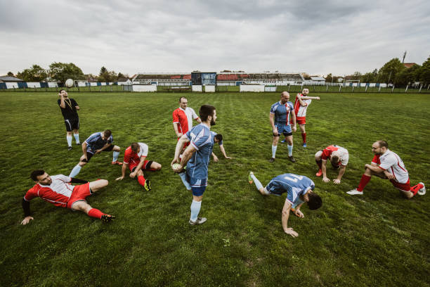 istock Large group of rugby players stretching before a match on playing field. 1157722642