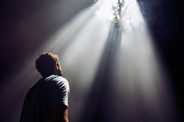 istock Carefree man looking at sunbeam entering the cave. 1157724564