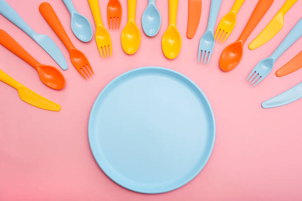 istock Colorful tableware : spoon, knife, fork and plate blue color on pink background. 1157727431