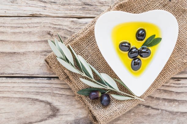 istock Olive oil and olives on rustic wooden background copy space. 1157728865
