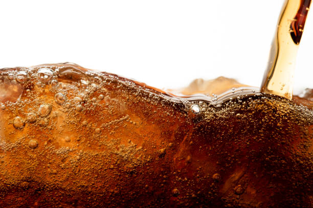 cierre la cola vertiendo con hielo y burbuja en vidrio sobre bebida fría de fondo blanco - coke fotografías e imágenes de stock