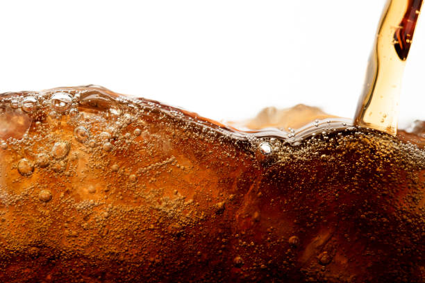Close up cola pouring with ice and bubble in glass on white background cold drink beverage Close up cola pouring with ice and bubble in glass on white background cold drink beverage soda pop stock pictures, royalty-free photos & images