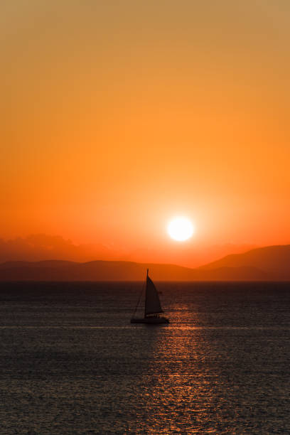 Lonely yacht at sea during sunrise in the early morning.