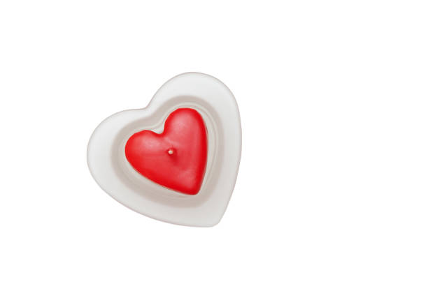 istock Red candle in the shape of a heart in a glass candlestick. White isolate. 1157731490