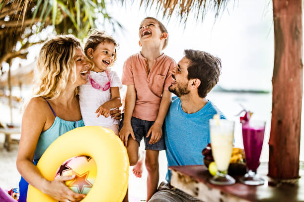 istock Young happy family having fun while spending a summer day in a beach cafe. 1157732210