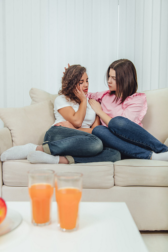 True friend will always help you. Concept of friendship and support. Apple and juice on the blurred forefront. Full-length shot of two lovely girls.