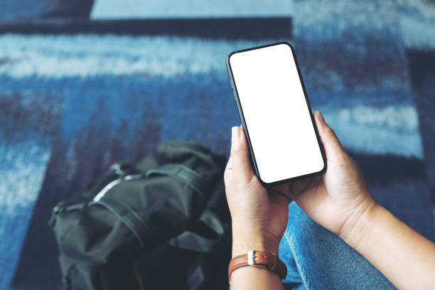 istock a woman's hands holding and using black mobile phone with blank screen while sitting in the airport 1157733510