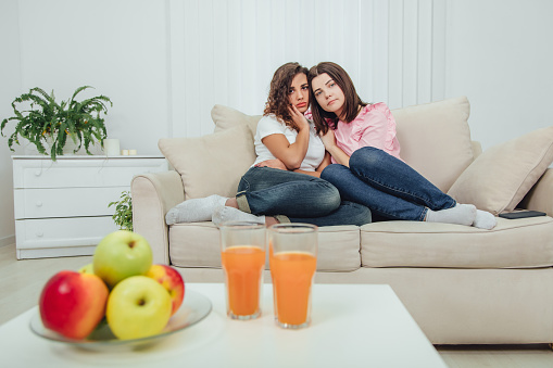 True friend will always help you. Concept of friendship and support. Apple and juice on the blurred forefront. Full-length shot of two lovely girls.