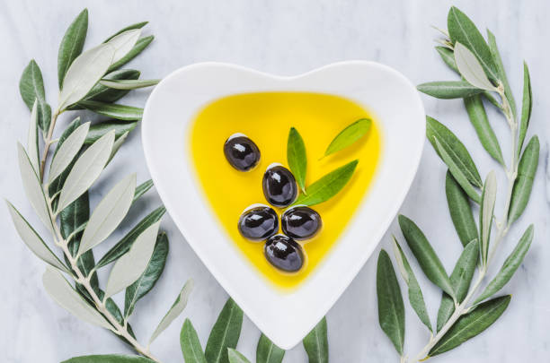 istock Olive oil bowl and olives on white marble table. 1157733818