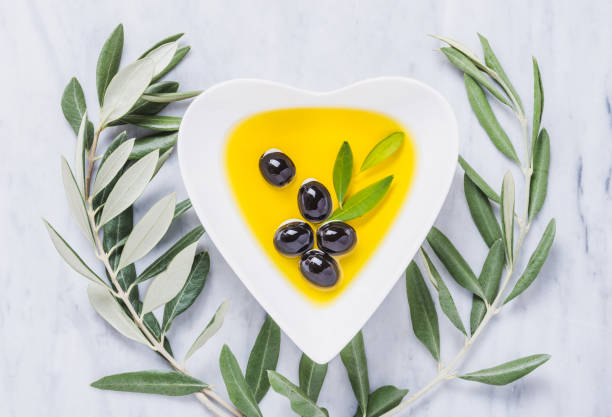 bol de aceite de oliva y aceitunas frescas sobre mesa de mármol blanco. prueba de aceite de oliva virgen extra fresco. - olive olive tree italy italian culture fotografías e imágenes de stock