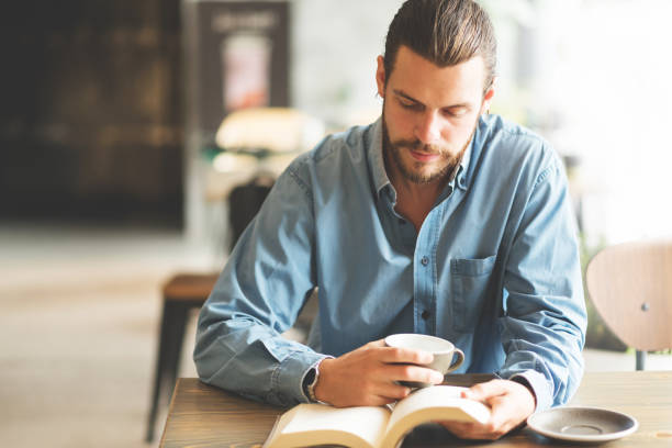 istock Male freelancer in blue shirt reading a book. 1157735034