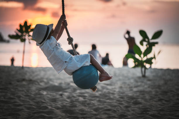 The happy time of the little girl on the swing in the children's paradise