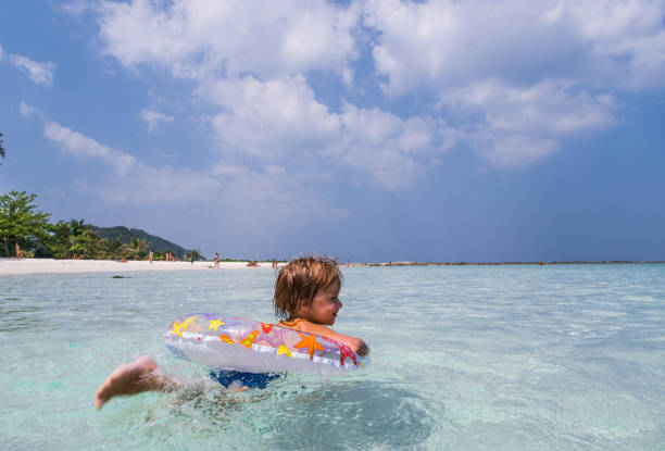 istock Smiling little boy enjoying while swimming in inflatable ring at sea. 1157736259
