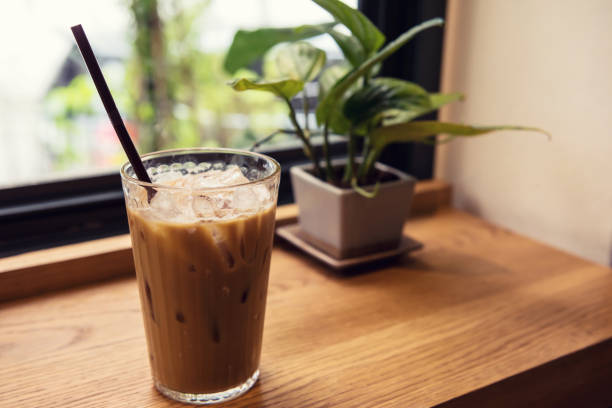 istock Ice coffee on wood table near window 1157736347