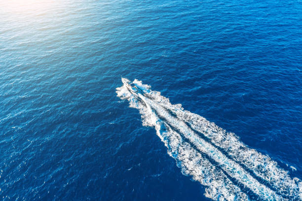 il lancio della barca ad alta velocità galleggia alla luce del sole nel mediterraneo, vista aerea dall'alto. - speedboat leisure activity relaxation recreational boat foto e immagini stock