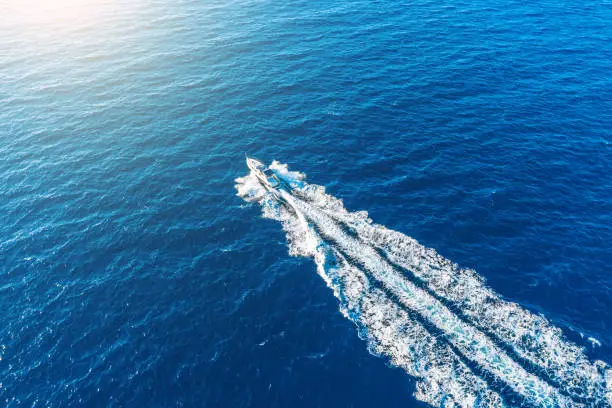 Photo of Boat launch at high speed floats to sunlight in the Mediterranean, aerial top view.