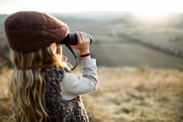 istock Small girl looking through binoculars in nature. 1157737508