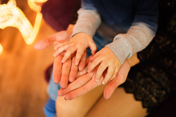 mani dei bambini nei palmi della madre - multi generation family adoption family human hand foto e immagini stock