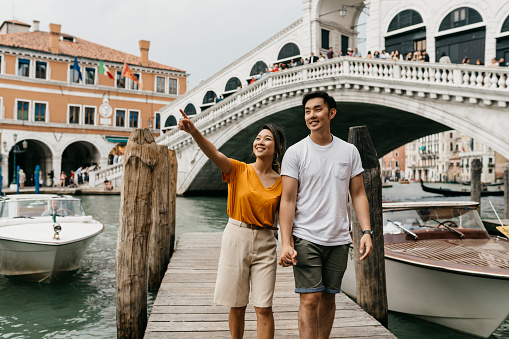Young adult asian couple exploring Venice, Italy