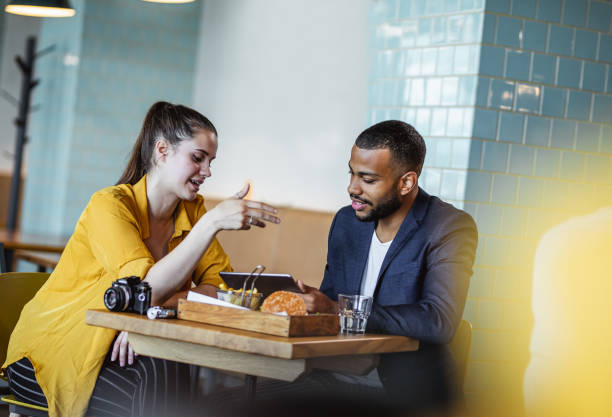 istock Two Young Coworkers Meeting at a Restaurant, Cafeteria 1157741182