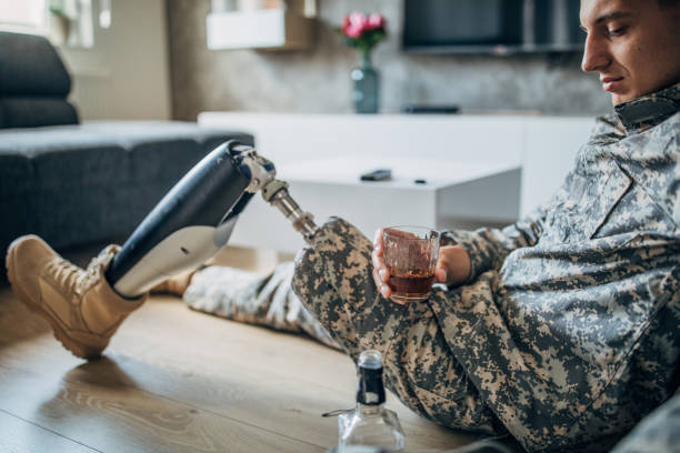 istock Depressed soldier with amputee leg drinking alcohol 1157742169