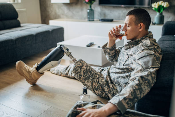istock Depressed soldier with amputee leg drinking alcohol 1157742224
