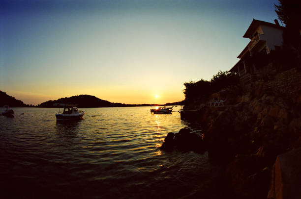 spectacular sunset among the fishing boats of Dubrovnik with red and yellow reflections on the sea